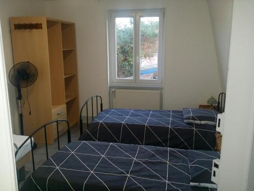 two beds in a room with a window at Gîte Bartsch in Ungersheim