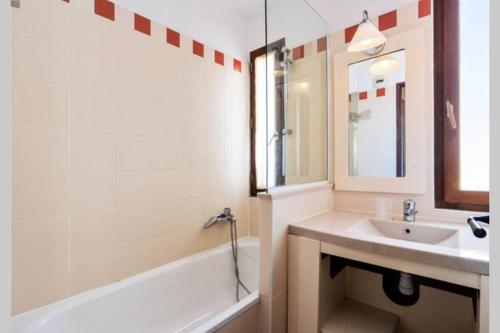 een badkamer met een wastafel, een bad en een spiegel bij T4 Vue exceptionnelle sur le Golf du Lion in Cap d'Agde