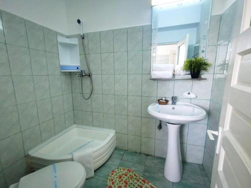 a bathroom with a sink and a toilet and a tub at Berlin - Locatie Centrala in Eforie Nord