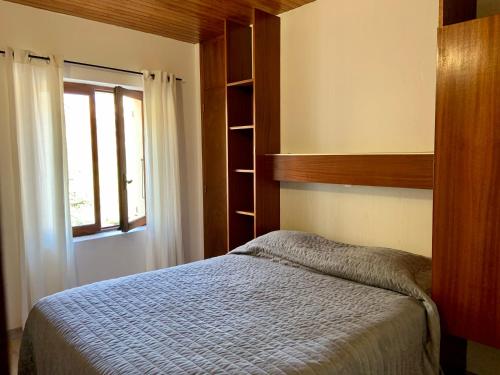 um quarto com uma cama e uma janela em Le Pidanoux em Saint-Julien-du-Verdon