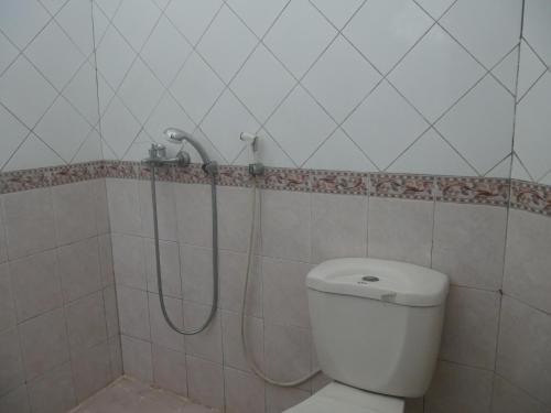 a shower in a bathroom with a toilet at Hotel Garuda Syariah near Alun Alun Banjarnegara in Wonosobo