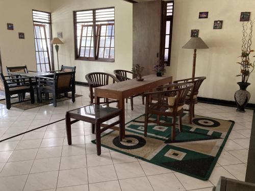 a dining room with a wooden table and chairs at Hotel Garuda Syariah near Alun Alun Banjarnegara in Wonosobo