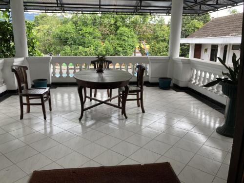 a porch with a table and chairs on a balcony at Hotel Garuda Syariah near Alun Alun Banjarnegara in Wonosobo