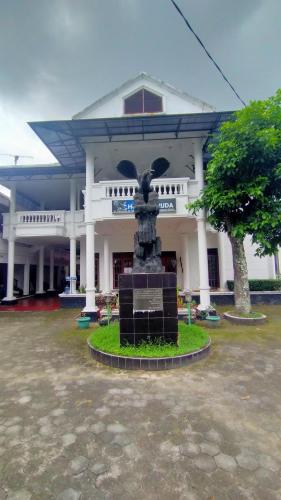 a building with a statue in front of it at Hotel Garuda Syariah near Alun Alun Banjarnegara in Wonosobo