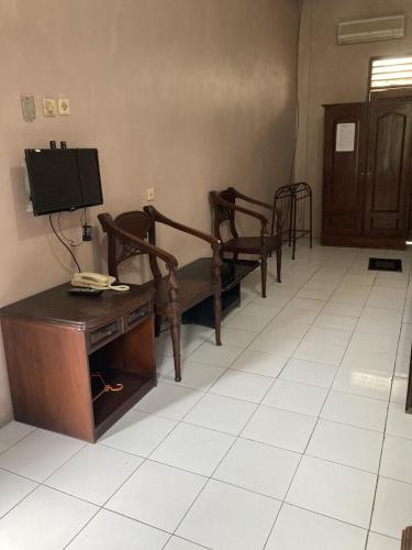 a hospital room with two beds and a tv at Hotel Garuda Syariah near Alun Alun Banjarnegara in Wonosobo