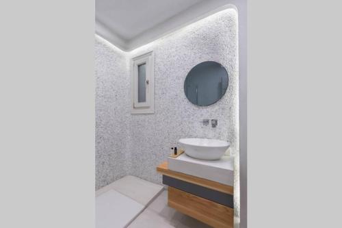 a bathroom with a sink and a mirror at Vivere InBlue - Deluxe apartment over the sea in Pera Gyalos