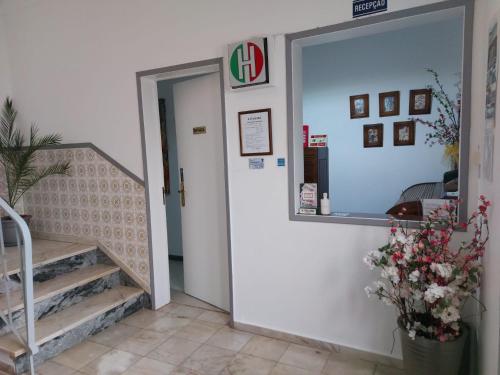 a entrance to a building with stairs and a mirror at Hospedaria A Italiana in Moura