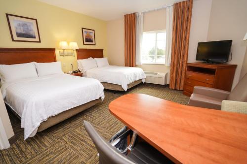 a hotel room with two beds and a flat screen tv at Candlewood Suites Boise - Towne Square, an IHG Hotel in Boise