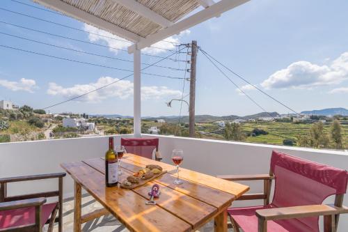 a wooden table with two glasses of wine on a balcony at Zanart maisonette II in Tripití
