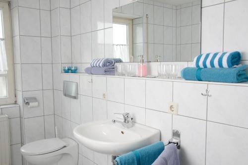un bagno con lavandino, WC e specchio di Landgasthof Schwanen a Ostrach