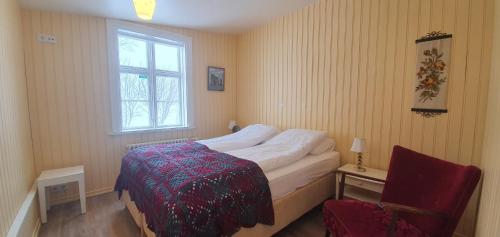 a bedroom with a bed and a chair and a window at Saudafell Guesthouse in Sauðafell