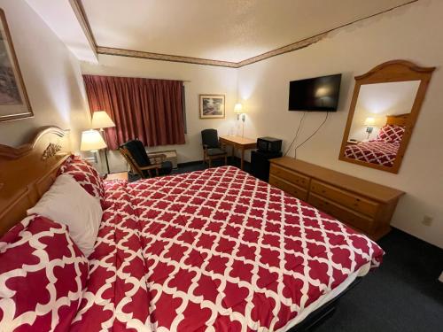 a hotel room with a bed and a mirror at Hunter Lodge in Ripley