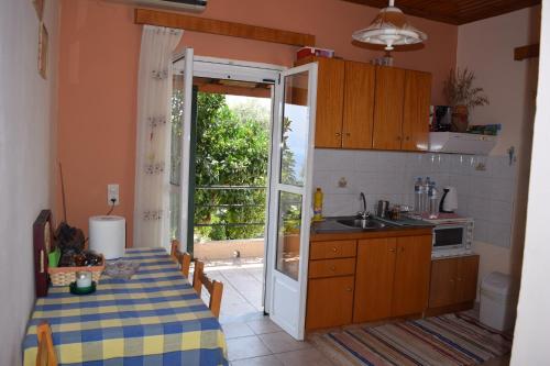 a kitchen with a table and a kitchen with an open door at Villa Ioanna in Koroni