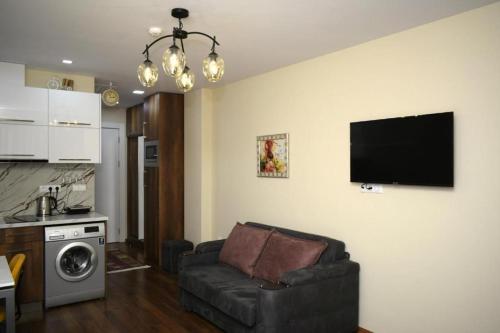 a living room with a couch and a tv on the wall at New Gudauri, Loft 2 in Gudauri