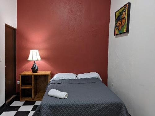 a small bedroom with a bed and a lamp at My Family In Monterrey - Hostel in Monterrey