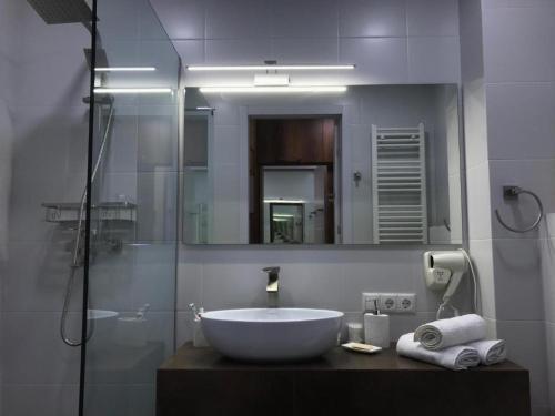 a bathroom with a sink and a shower with a mirror at New Gudauri, Loft 2 in Gudauri