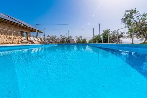 a large swimming pool with blue water at Alon Bagalil in Kahal