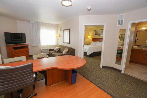 a living room with a table and a bedroom at Candlewood Suites Boise - Towne Square, an IHG Hotel in Boise