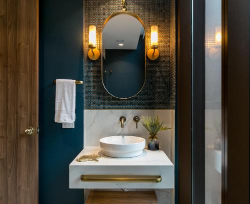 a bathroom with a white sink and a mirror at Hotel Marquee Medellín in Medellín
