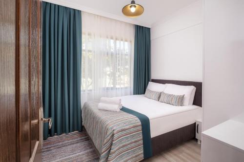 ein kleines Schlafzimmer mit einem Bett und einem Fenster in der Unterkunft Sayan Apart Hotel in Kemer