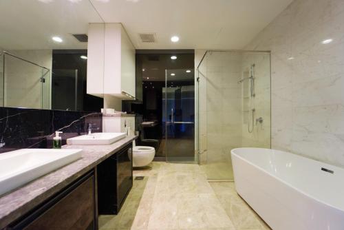 a bathroom with two sinks and a tub and a toilet at Luxe Suites at Platinum KLCC in Kuala Lumpur