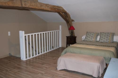 a bedroom with a bed and a stair case at Gîte de caractère in Le Vigeant