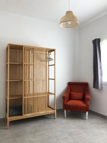 a room with a red chair and a book shelf at Casa do Viajante - Suite in Zambujeira do Mar