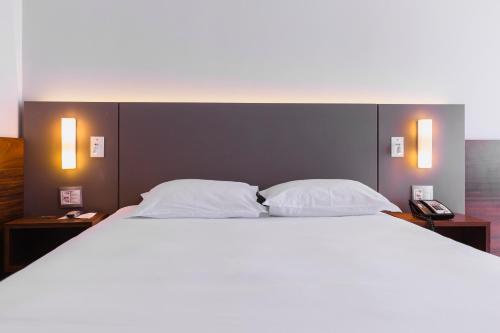 a bedroom with a large bed with two pillows at Bugan Recife Boa Viagem Hotel - by Atlantica in Recife