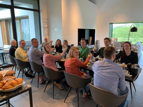 a group of people sitting at tables in a restaurant at De Koolputten in Waasmunster