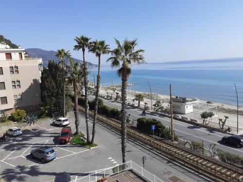 a view of a street with palm trees and the ocean at Alba Apartment in Laigueglia