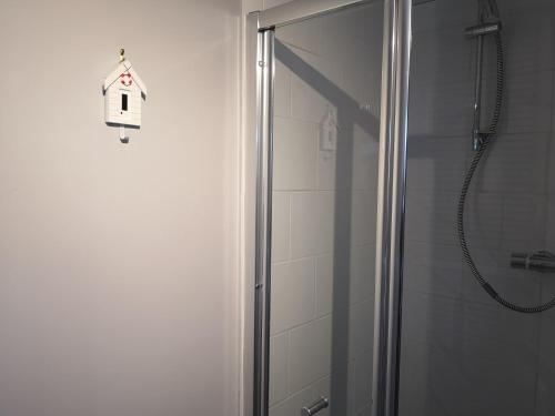 a shower with a glass door with a bird house on it at The Cambus Flat Cambuskenneth Stirling in Stirling
