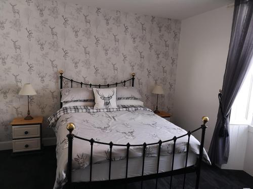 a bedroom with a black and white bed and a window at The Cambus Flat Cambuskenneth Stirling in Stirling