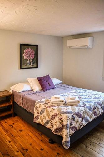 a bedroom with a bed with two towels on it at Brook Road Inn in Goshen