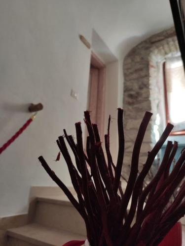 a vase filled with branches in a room at Regnos Altos boutique rooms in Bosa