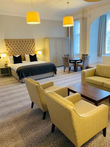 a hotel room with a bed and a table and chairs at Easthampstead Park in Bracknell