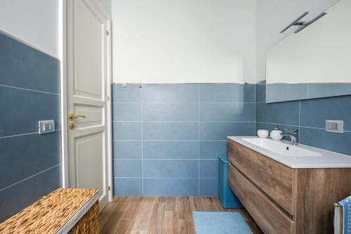 ein Bad mit einem Waschbecken und blauen Fliesen in der Unterkunft Anna's Luxury Apartment in Palermo