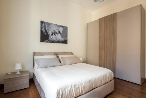 Schlafzimmer mit einem weißen Bett und Holzboden in der Unterkunft Anna's Luxury Apartment in Palermo