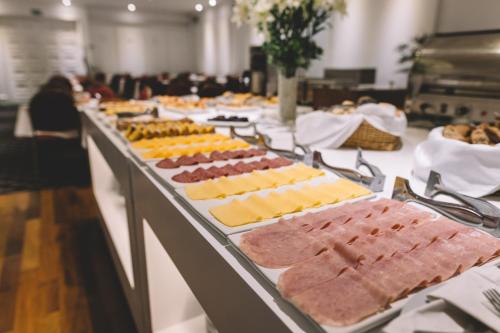 a buffet line with many different types of cheeses and meats at Hotel Dos Reyes in Mar del Plata