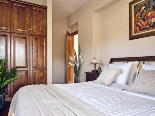 a bedroom with a white bed with a wooden door at Villa Castelletto heated pool jacuzzi in Kipseli