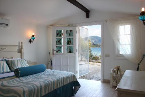 a bedroom with a bed and a sliding glass door at Losta Sahil Evi - Adults Only +12 in Selimiye