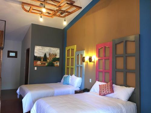 - 2 lits dans une chambre dotée de portes colorées dans l'établissement Gran Barrio, à San Cristóbal de Las Casas