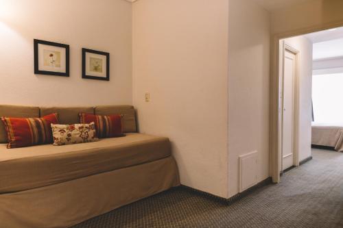 a bedroom with a bed with pillows on it at Hotel Dos Reyes in Mar del Plata