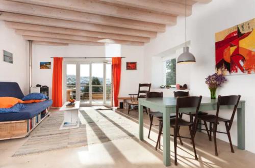 a dining room and living room with a table and chairs at Romantic riverside retreat in Odemira
