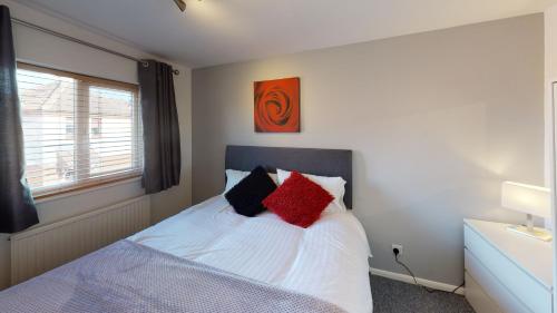 1 dormitorio con 1 cama con almohadas rojas y negras en Marina House, en Hull
