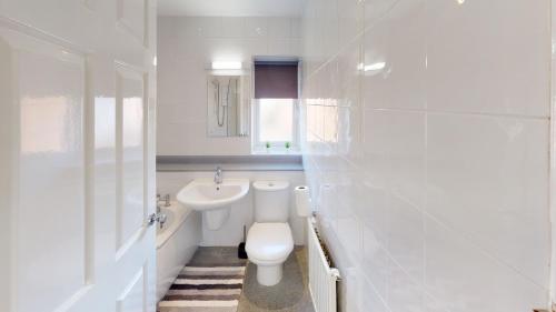 a white bathroom with a toilet and a sink at Marina House in Hull