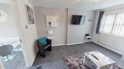 a living room with a black chair and a table at Marina House in Hull