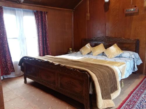 1 dormitorio con 1 cama grande con marco de madera en Houseboat Moon of Kashmir, en Srinagar