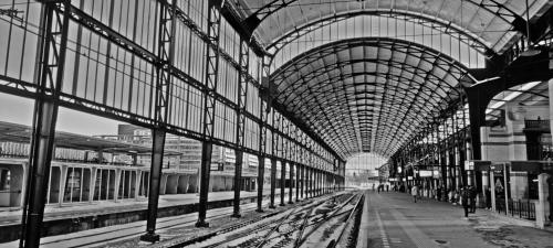 a black and white photo of a train station with two trains at Hotelhuisje Warmenhuizen #D in Warmenhuizen