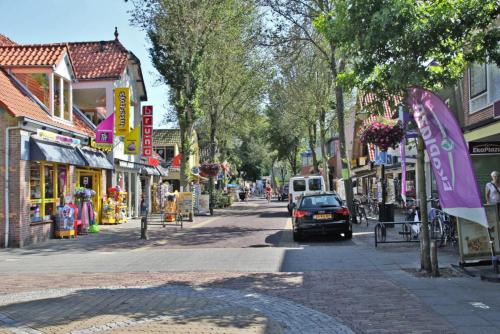 a street in a town with a car parked on the street at Hotelhuisje Warmenhuizen #D in Warmenhuizen