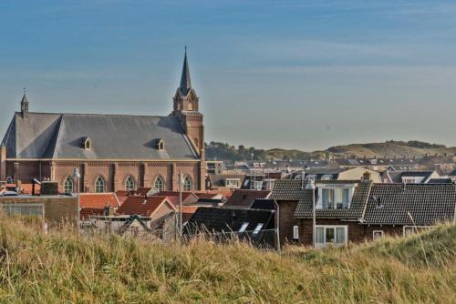 a group of buildings with a church and a tower at Hotelhuisje Warmenhuizen #B in Warmenhuizen